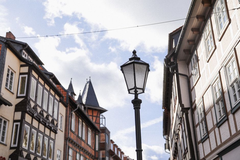 Vintage street lamp amidst half-timbered buildings in Wernigerode, Germany. Bright day setting.