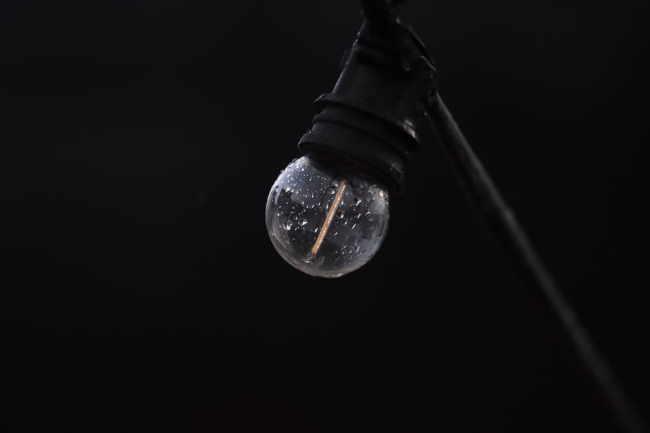 Glühbirne mit sichtbarer Fassung an einem Kabel